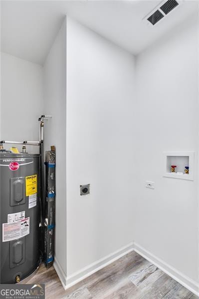 clothes washing area featuring electric water heater, hardwood / wood-style floors, washer hookup, and hookup for an electric dryer