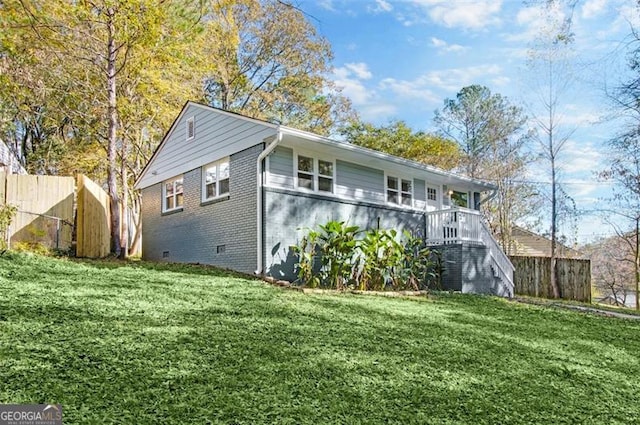 view of property exterior with a lawn and a deck