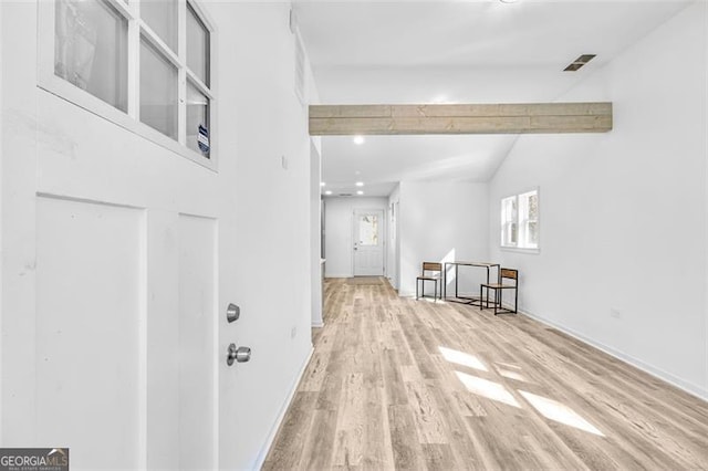 interior space with lofted ceiling with beams and light hardwood / wood-style floors