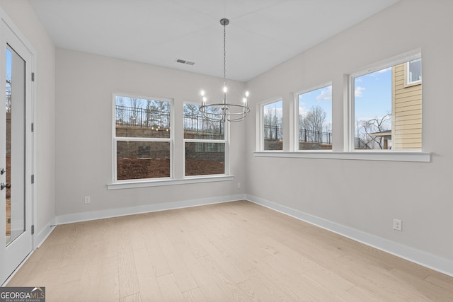 unfurnished dining area featuring a chandelier and light wood-type flooring