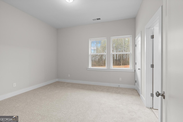 spare room featuring light colored carpet