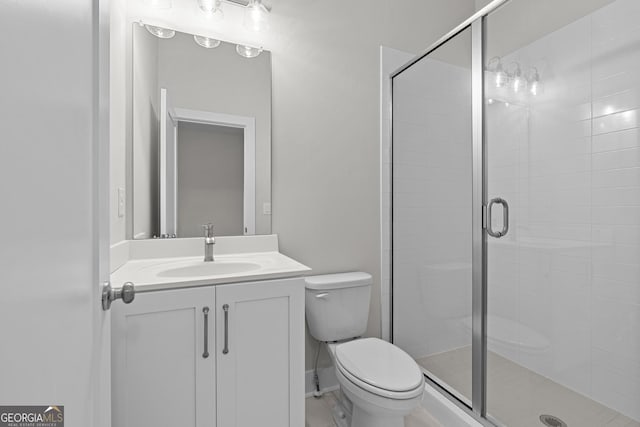 bathroom with vanity, a shower with shower door, and toilet