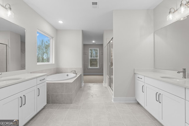 bathroom featuring vanity, independent shower and bath, and a wealth of natural light