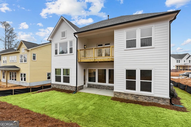 rear view of property featuring a patio, a balcony, and a yard