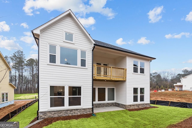 back of property featuring a lawn, a balcony, and a patio area