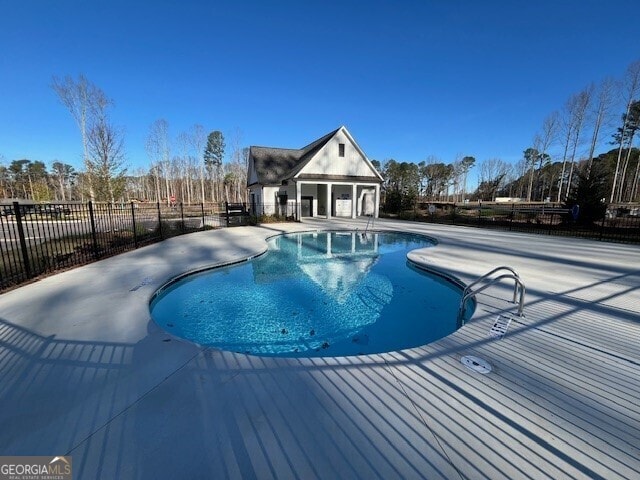 view of pool featuring an outbuilding and a patio