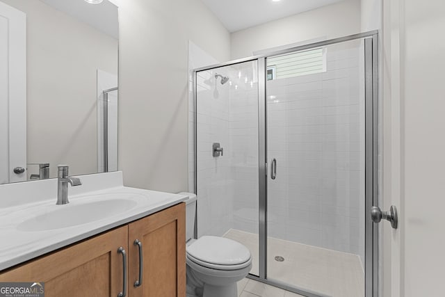 bathroom featuring vanity, a shower with shower door, and toilet