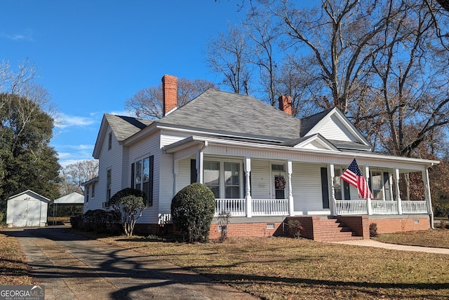 view of front facade with an outbuilding and a front lawn