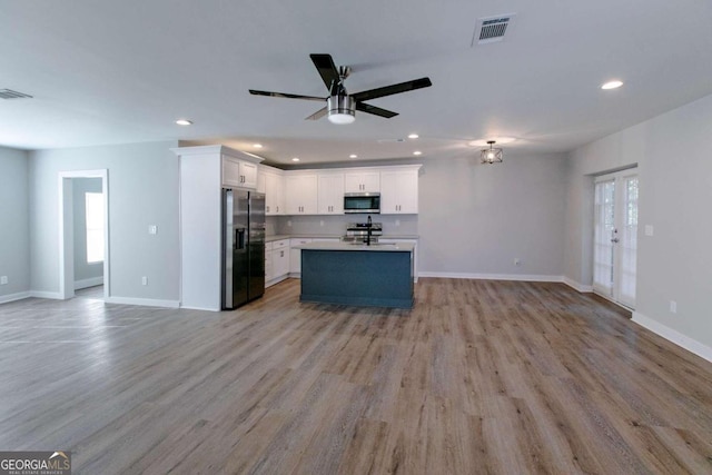 kitchen with light wood-type flooring, white cabinetry, and stainless steel appliances