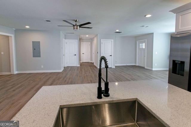 interior space featuring hardwood / wood-style floors, light stone countertops, and stainless steel refrigerator with ice dispenser