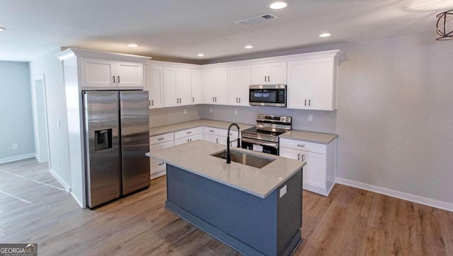 kitchen featuring white cabinetry, sink, stainless steel appliances, and light wood-type flooring