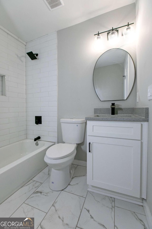 full bathroom featuring vanity, tiled shower / bath combo, and toilet