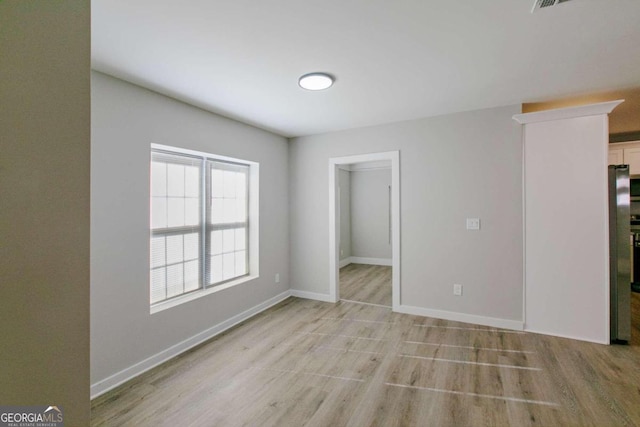 unfurnished room with light wood-type flooring