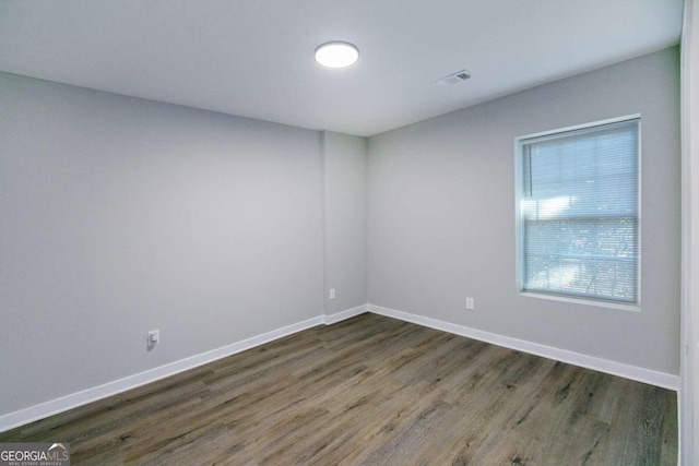 unfurnished room with dark hardwood / wood-style flooring