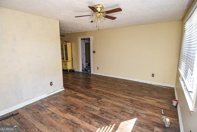 unfurnished room with a textured ceiling, ceiling fan, and dark wood-type flooring