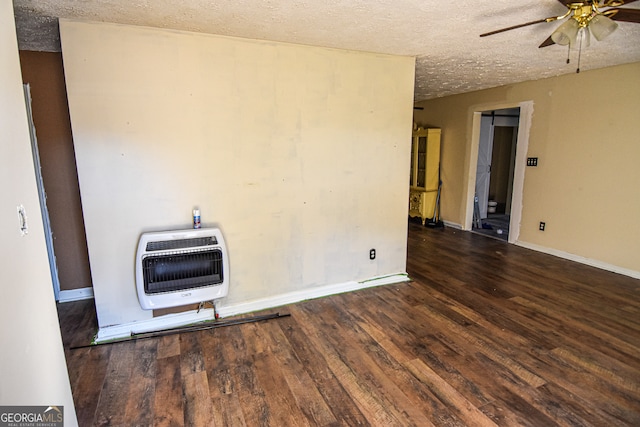 unfurnished room featuring a textured ceiling, dark wood-type flooring, and heating unit