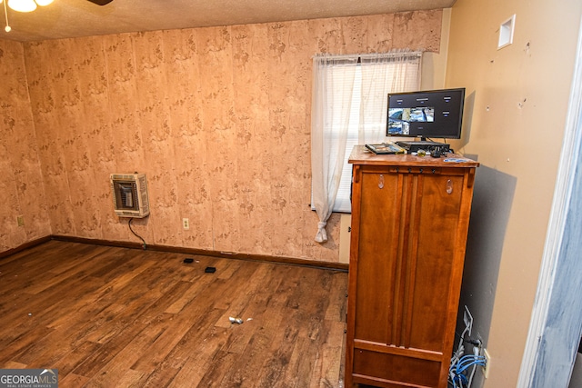 interior space with hardwood / wood-style floors, ceiling fan, a textured ceiling, and heating unit