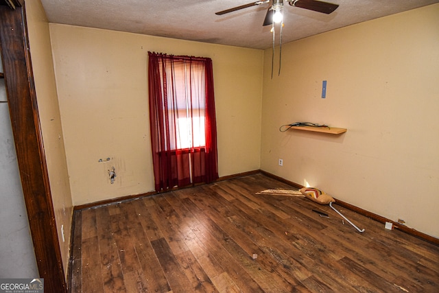 empty room with ceiling fan, dark hardwood / wood-style flooring, and a textured ceiling