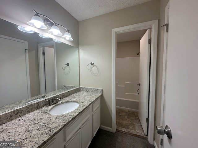 bathroom with vanity, a textured ceiling, and washtub / shower combination