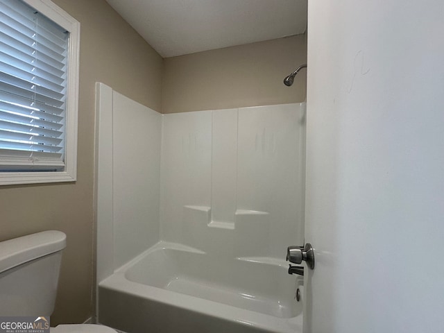 bathroom with toilet and washtub / shower combination