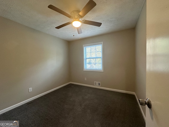 empty room with ceiling fan, a textured ceiling, and dark colored carpet