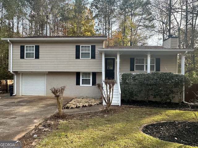 split level home featuring a garage and a front lawn