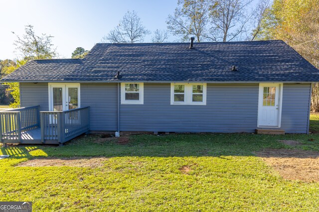 rear view of house with a deck, a yard, and french doors