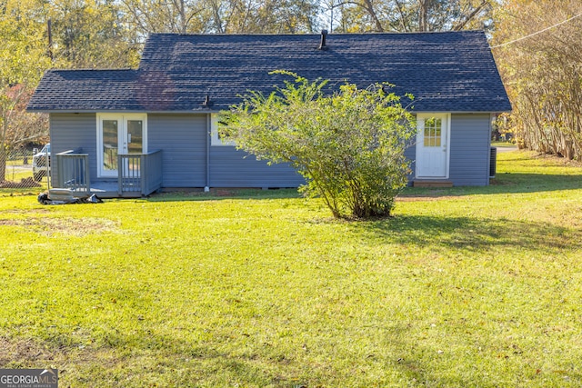 rear view of property with a lawn and french doors