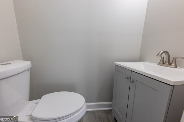 bathroom featuring hardwood / wood-style flooring, vanity, and toilet