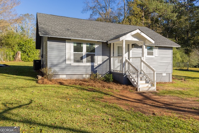 bungalow-style home with a front lawn and central AC unit