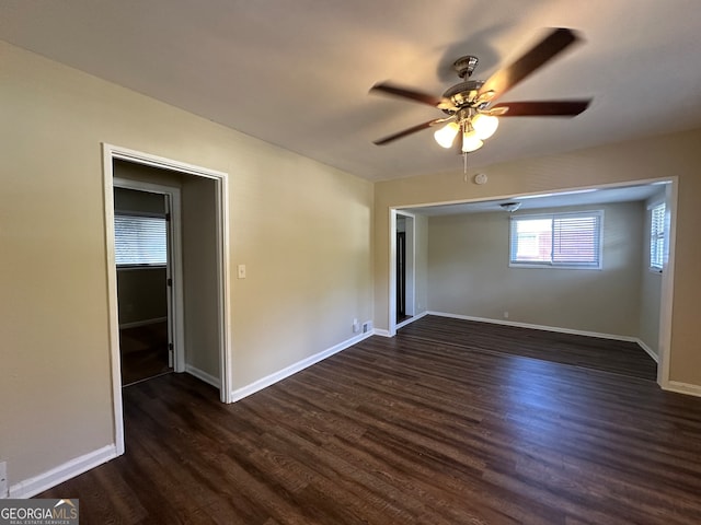 empty room with ceiling fan and dark wood-type flooring