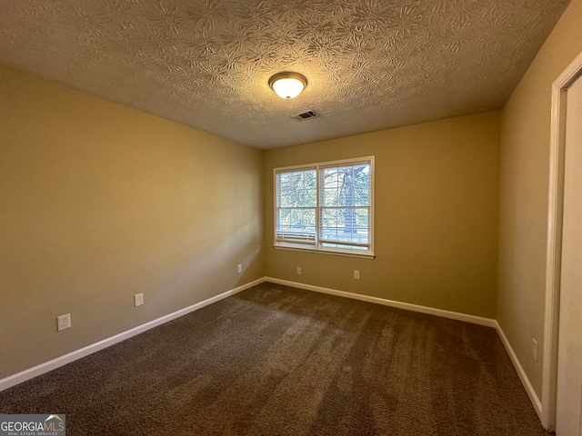 carpeted empty room with a textured ceiling