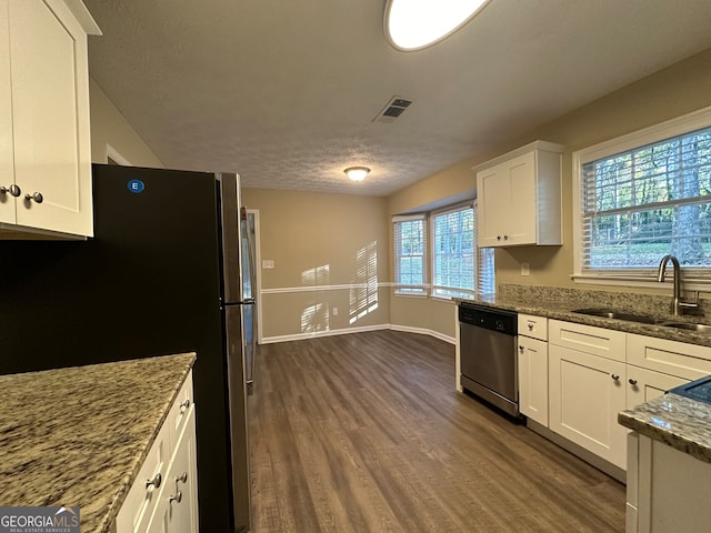 kitchen featuring light stone countertops, appliances with stainless steel finishes, dark hardwood / wood-style flooring, sink, and white cabinets