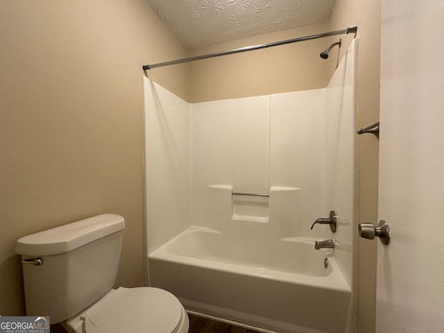 bathroom featuring toilet, wood-type flooring, a textured ceiling, and shower / washtub combination