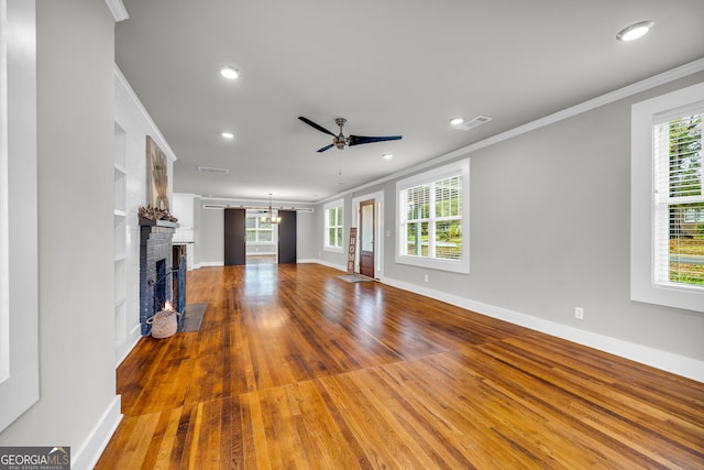 unfurnished living room with hardwood / wood-style floors, ceiling fan, and crown molding