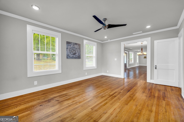 spare room with wood-type flooring, ceiling fan with notable chandelier, and ornamental molding