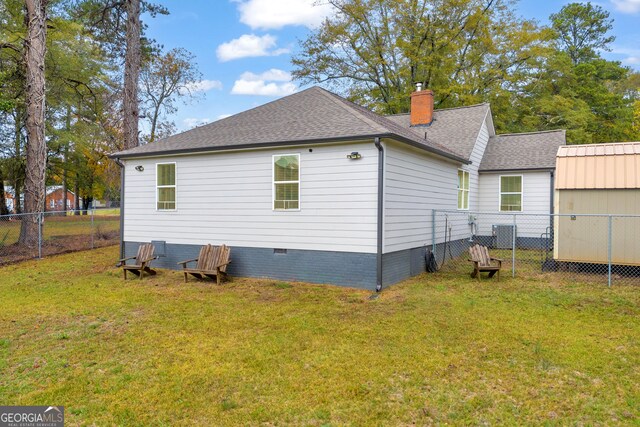 rear view of property featuring a yard and central AC unit