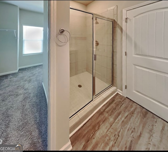 bathroom featuring hardwood / wood-style floors and a shower with door