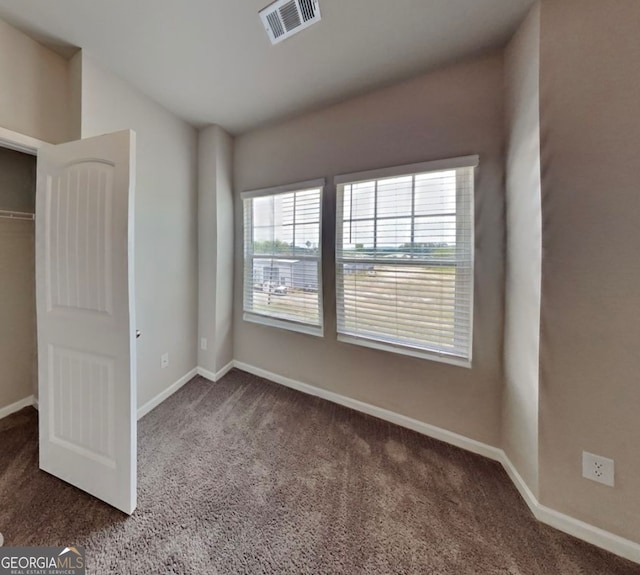 unfurnished bedroom with dark colored carpet