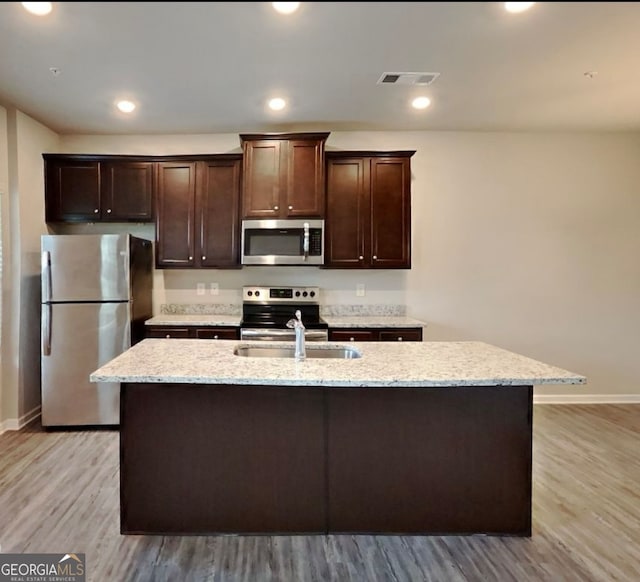 kitchen featuring a center island with sink, light hardwood / wood-style floors, and stainless steel appliances