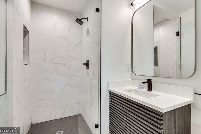 bathroom featuring a tile shower and vanity