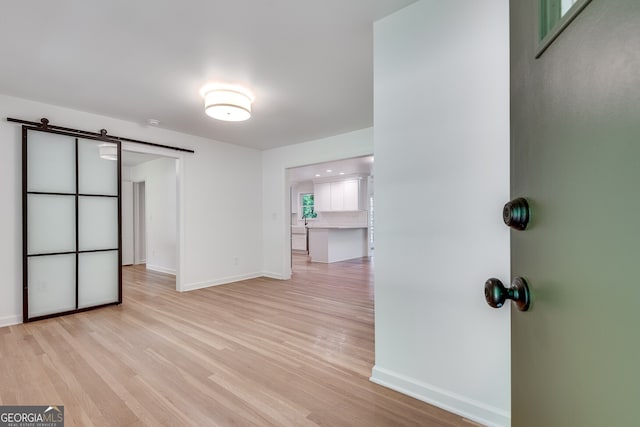 interior space with light hardwood / wood-style floors and a barn door