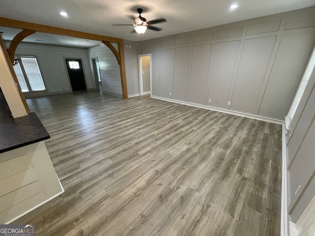 unfurnished living room featuring hardwood / wood-style floors, ceiling fan, and a textured ceiling