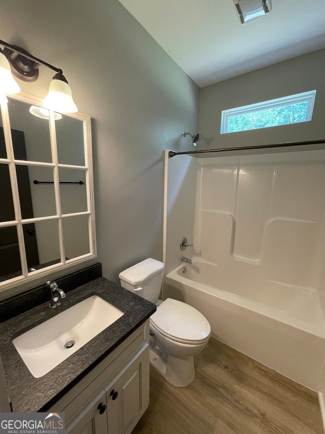 full bathroom with toilet, vanity, bathtub / shower combination, and hardwood / wood-style flooring