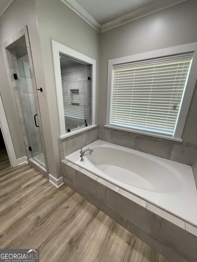 bathroom with crown molding, plus walk in shower, and hardwood / wood-style flooring