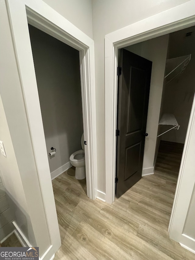 bathroom with wood-type flooring and toilet