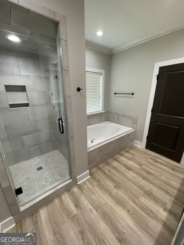 bathroom with separate shower and tub, wood-type flooring, and ornamental molding