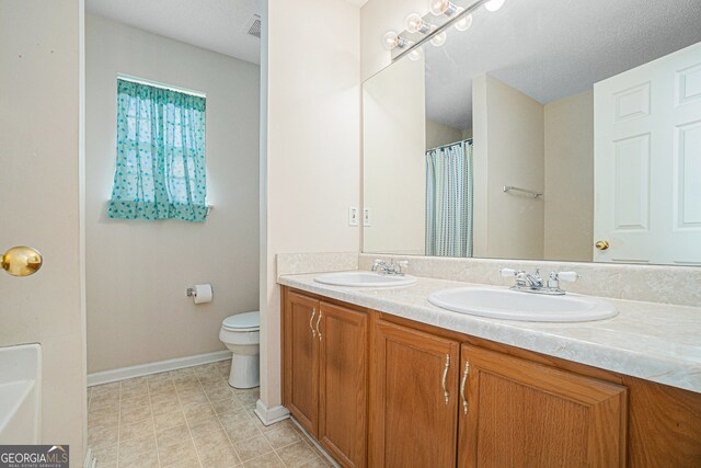 bathroom featuring vanity, toilet, and a textured ceiling