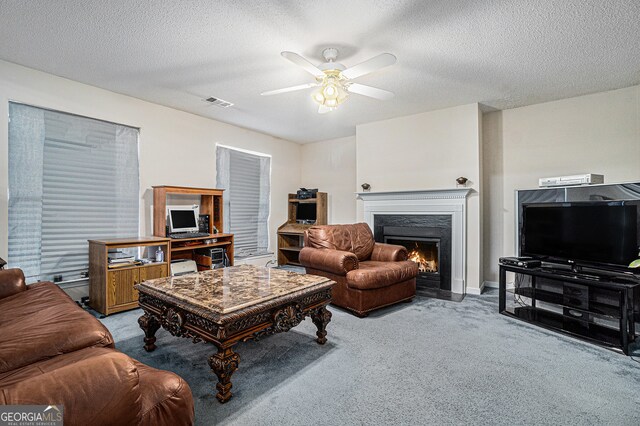 carpeted living room with ceiling fan and a textured ceiling