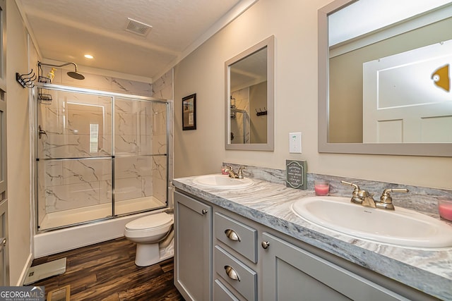 bathroom featuring an enclosed shower, vanity, a textured ceiling, hardwood / wood-style floors, and toilet